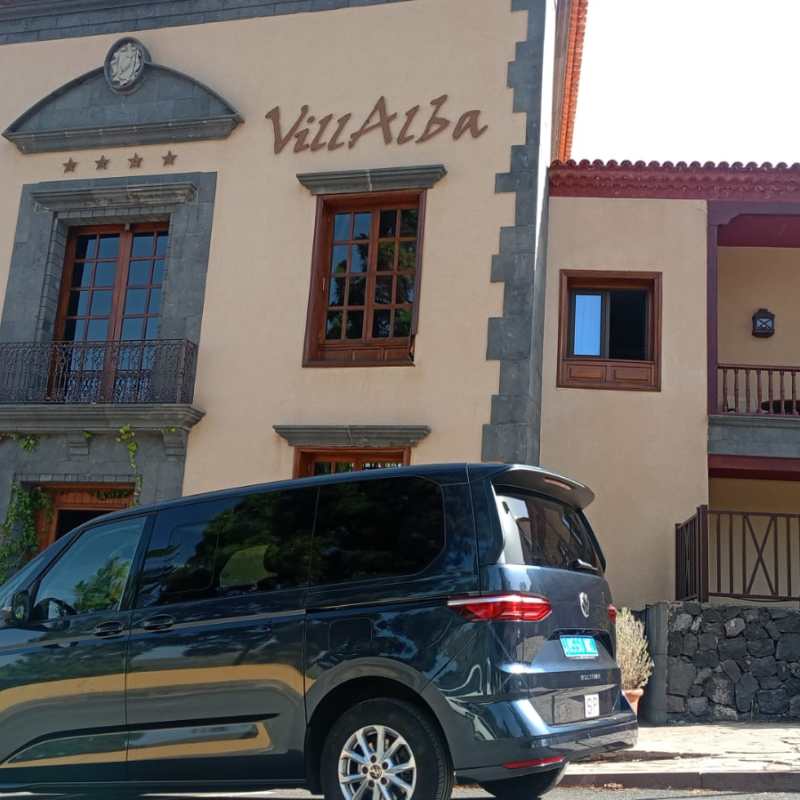 Black van parked in front of Hotel Villalba building.
